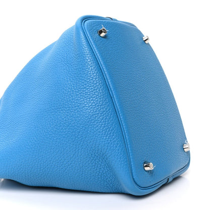 Blue leather tote bag with top handle and silver-tone lock hardware, angled view