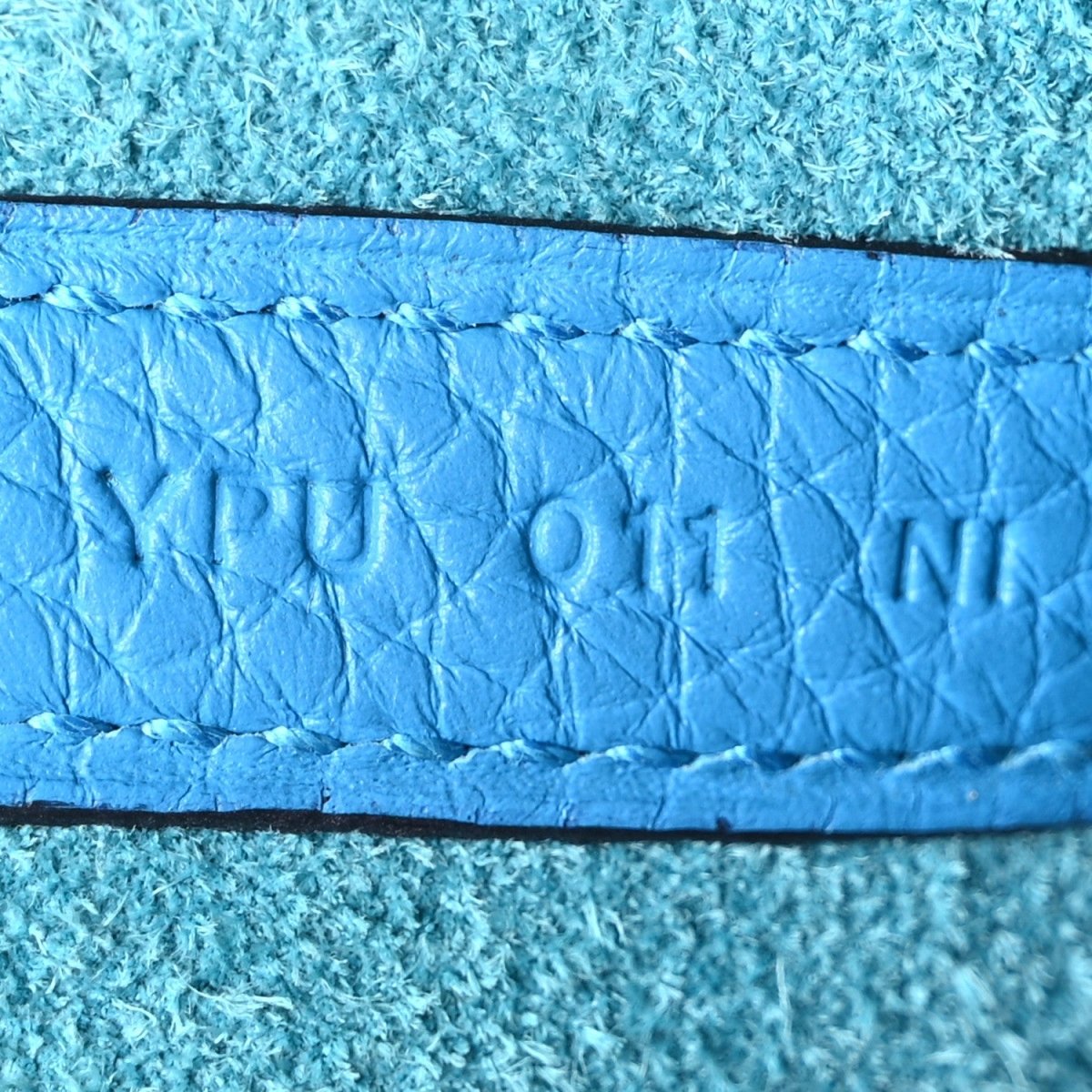 Blue leather interior edge with embossed lettering and small stamp details