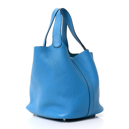Blue leather bucket-style tote bag with top handles and side seam detail