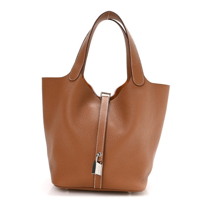 Tan leather mini tote with vertical lock closure and two top handles