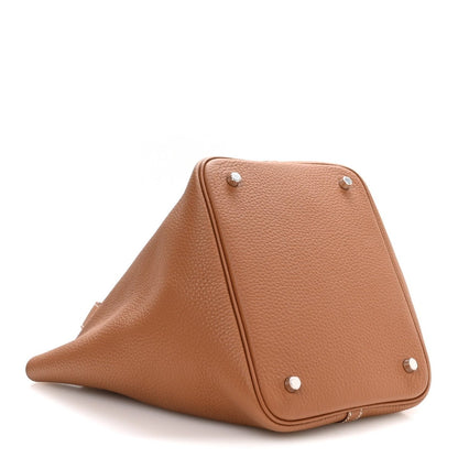 Tan triangular leather mini tote with metal feet and corner snap studs