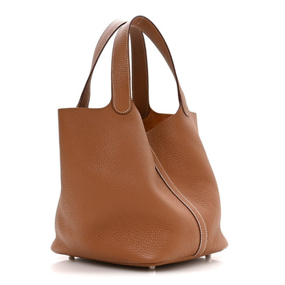 Tan pebbled leather mini tote with curved sides and top double handles