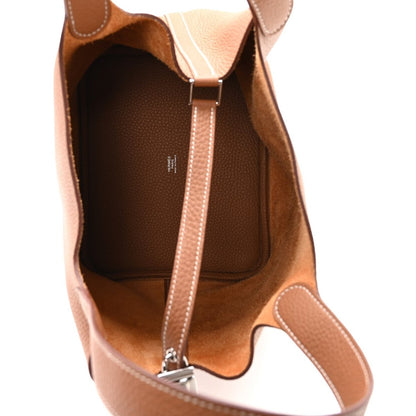 Tan leather mini tote interior view with central lock strap and stitched trim
