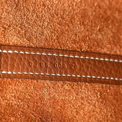 Leather tote bag close-up of stitched strap with stamped code text
