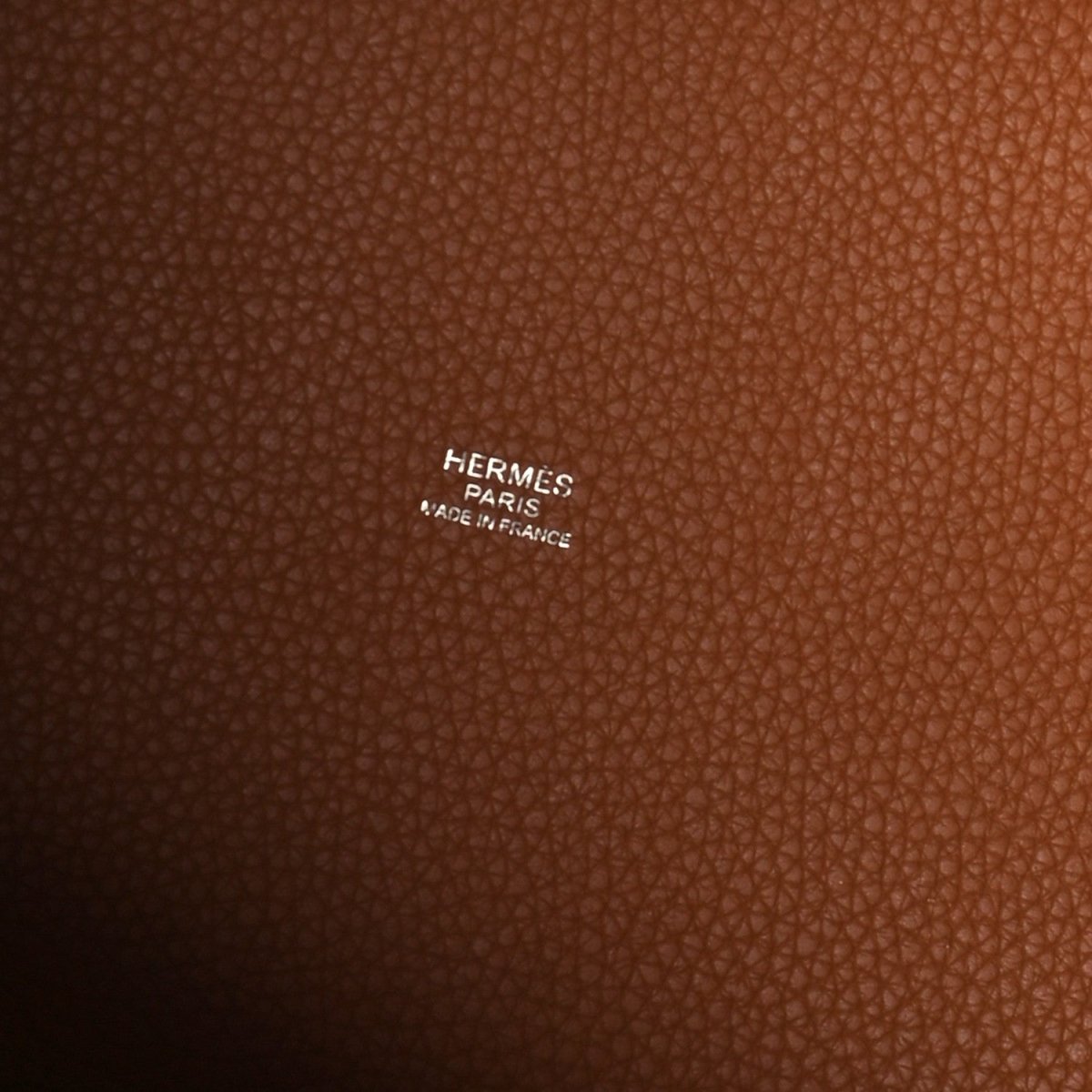 Golden brown leather tote bag interior showing Hermes Paris Made in France stamp