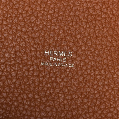Golden brown leather tote bag exterior texture with Hermes Paris Made in France stamp