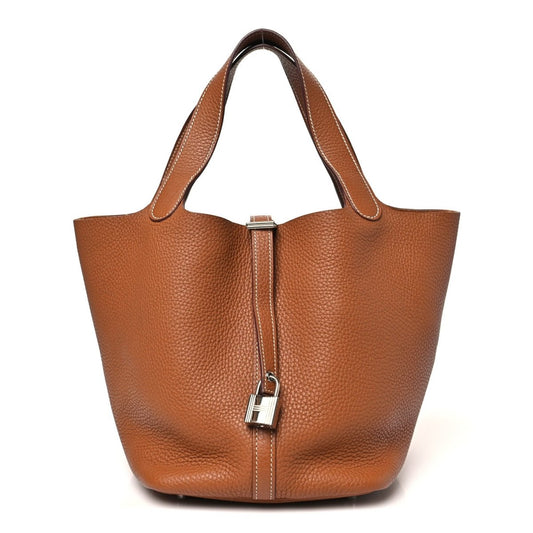 Golden brown leather tote bag with top handle and H lock clasp