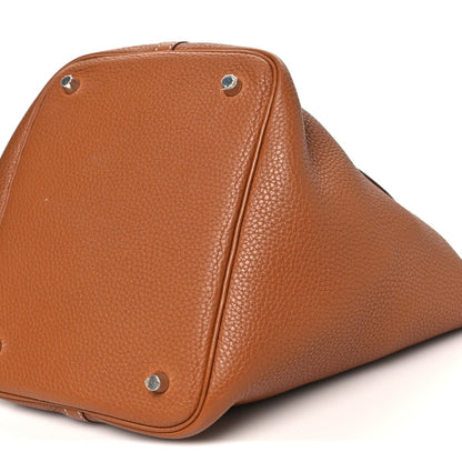 Golden brown leather tote bag close-up of corner with metal stud and stitching