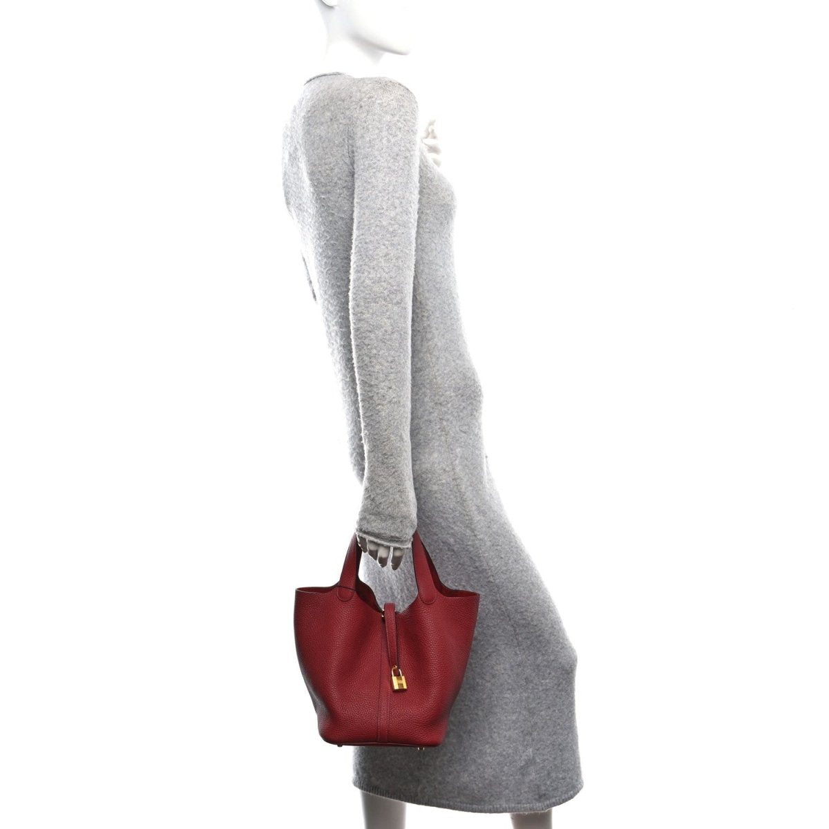 Red leather mini tote with top handles and gold lock zipper closure, side view