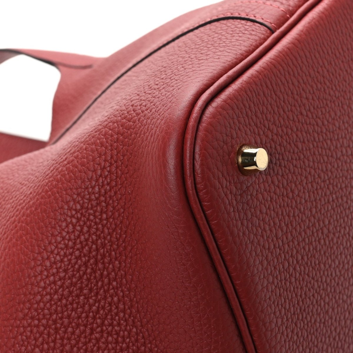 Red textured leather tote bag with gold hardware close-up