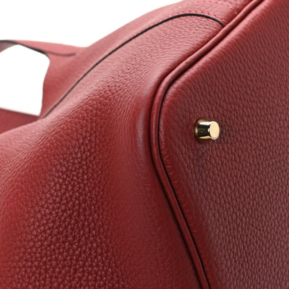 Red textured leather tote bag with gold hardware close-up