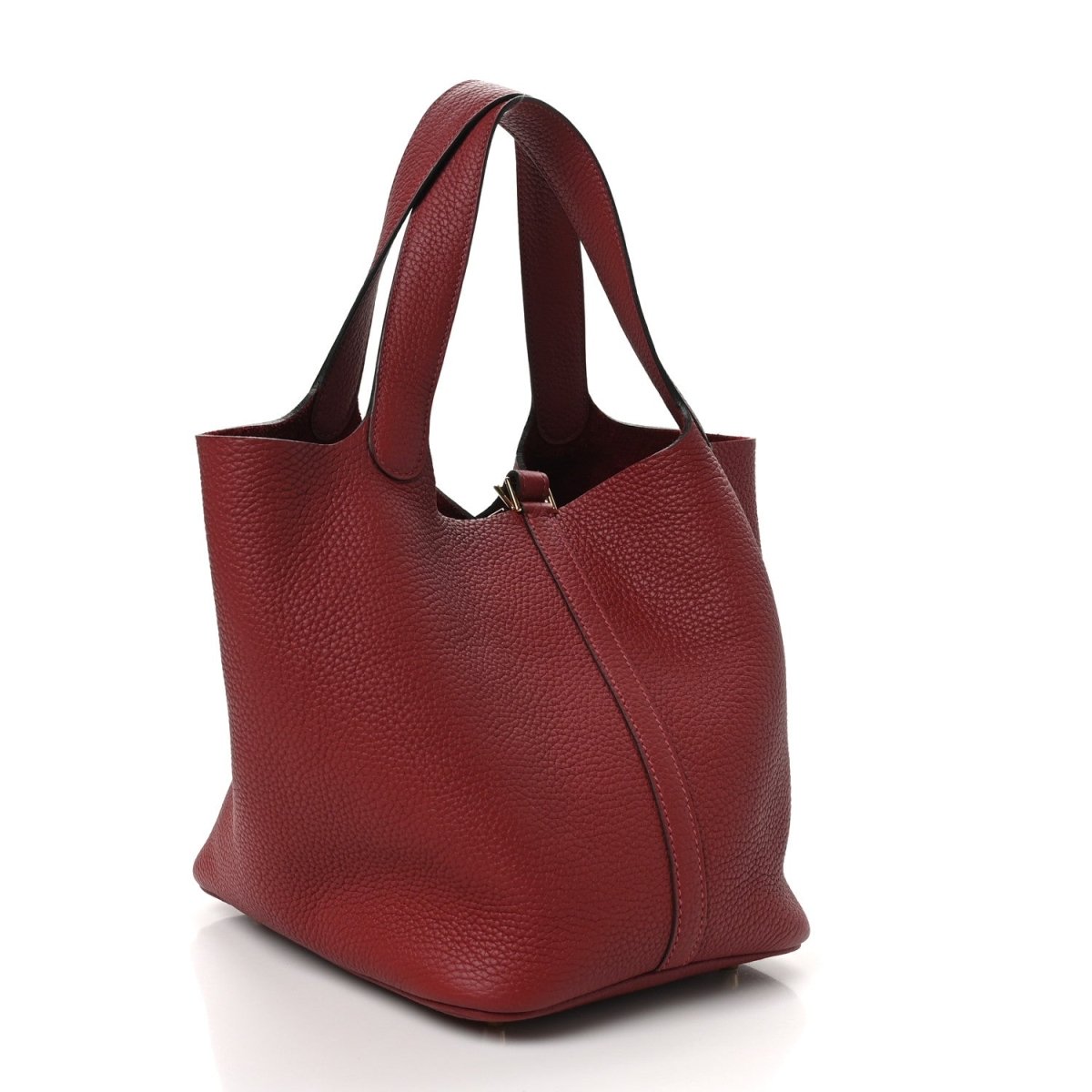 Red leather tote with top handles and lock zipper closure, angled view