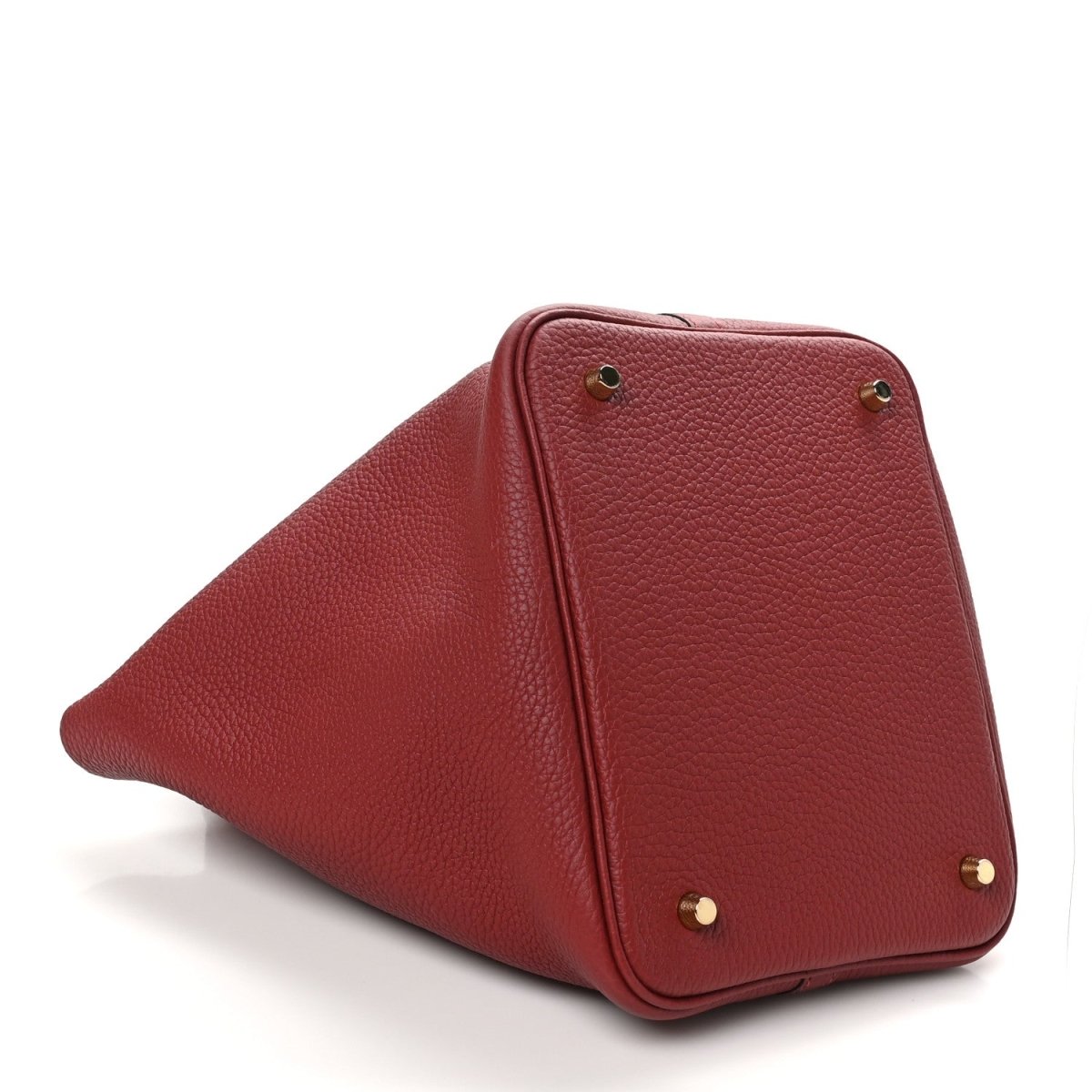 Red leather tote corner with gold hardware studs and curved side panel