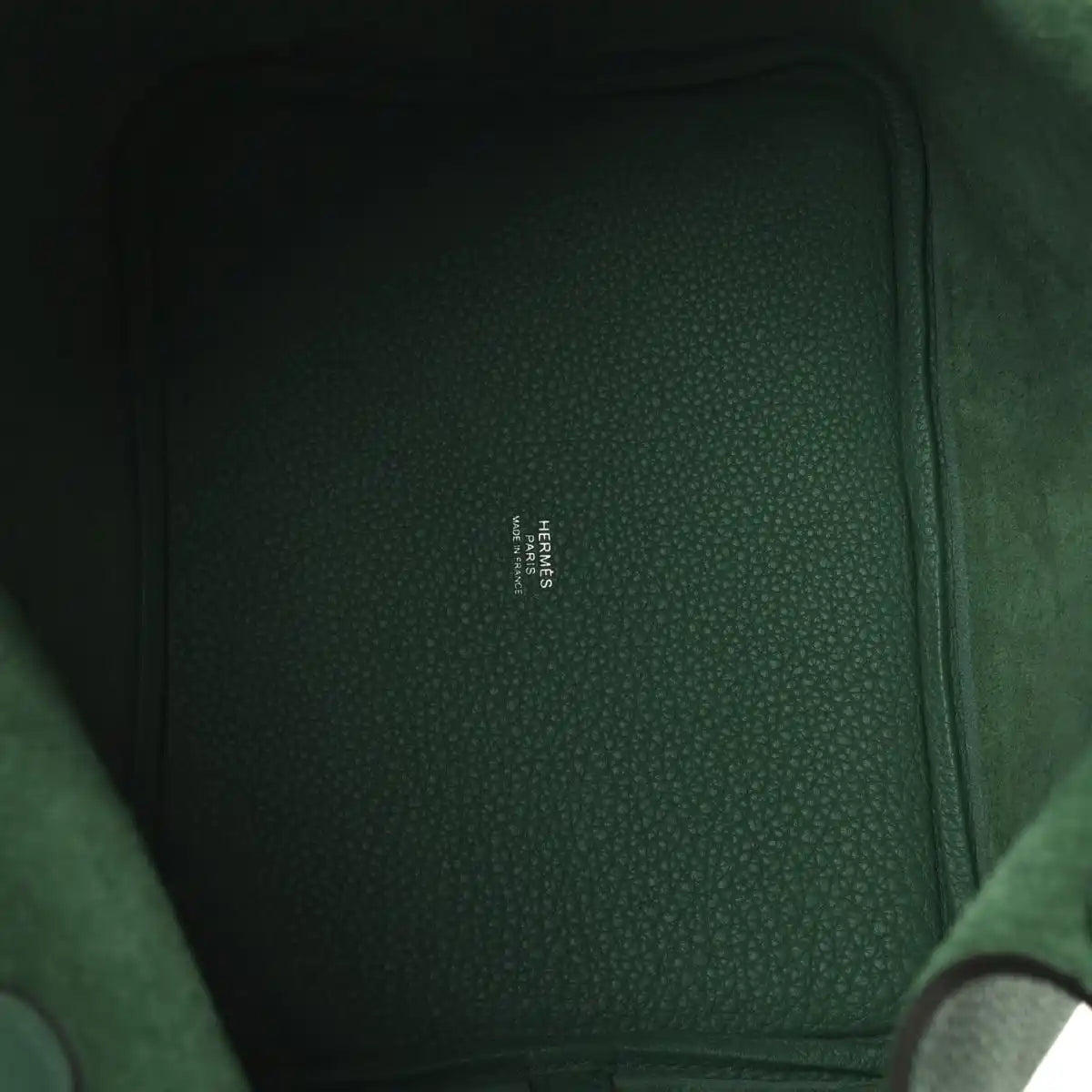 Green leather interior panel with small stamped brand text