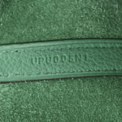Close-up of green leather trim with embossed serial-style text