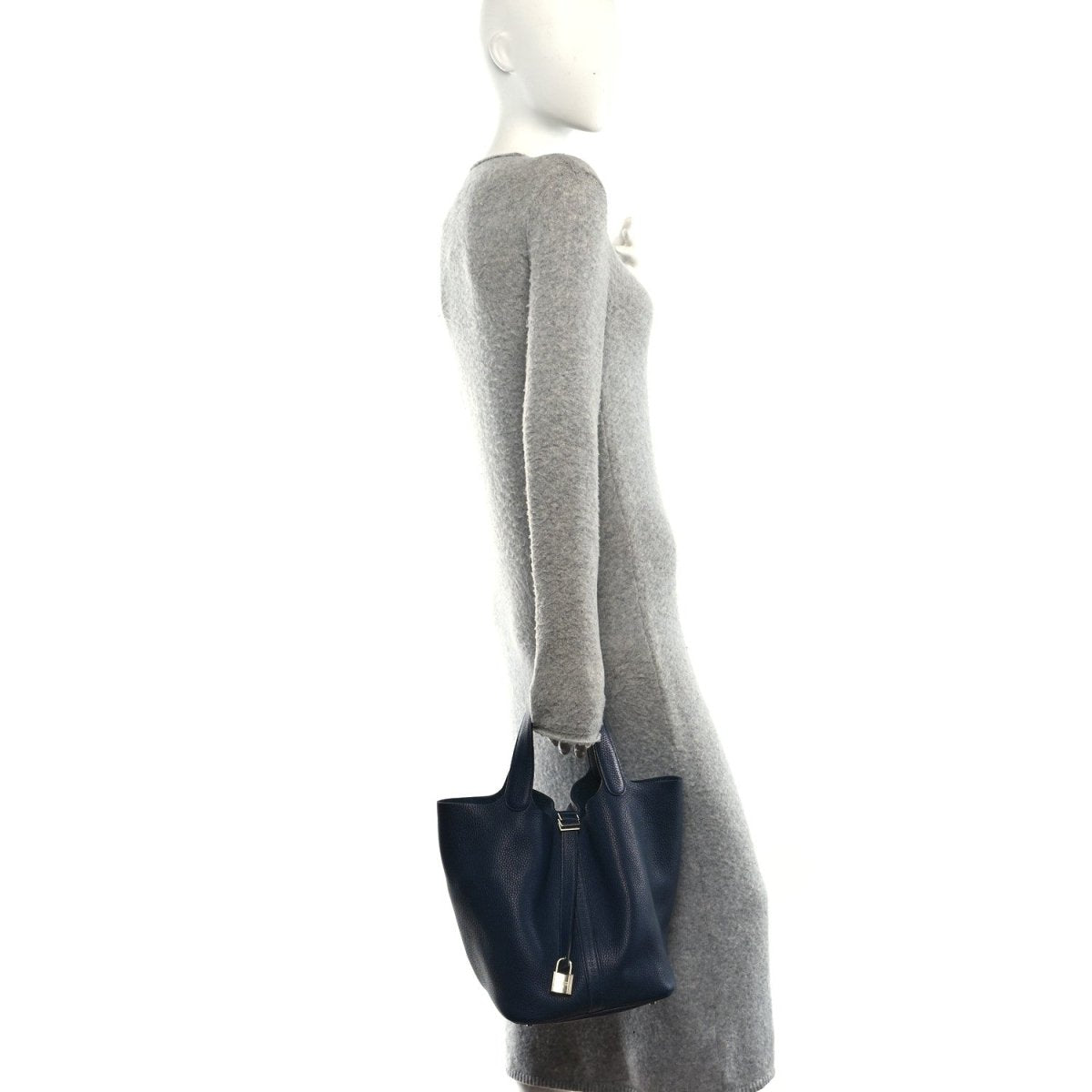 Dark navy leather tote bag on model, top handles and metal lock closure