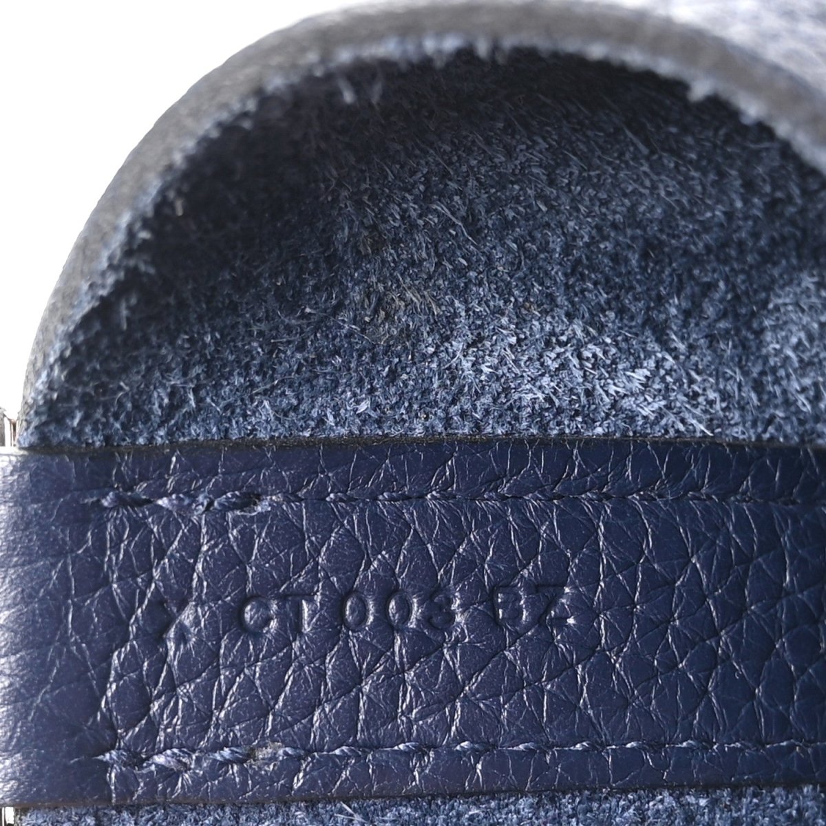 Navy leather strap edge with layered stitching and textured finish