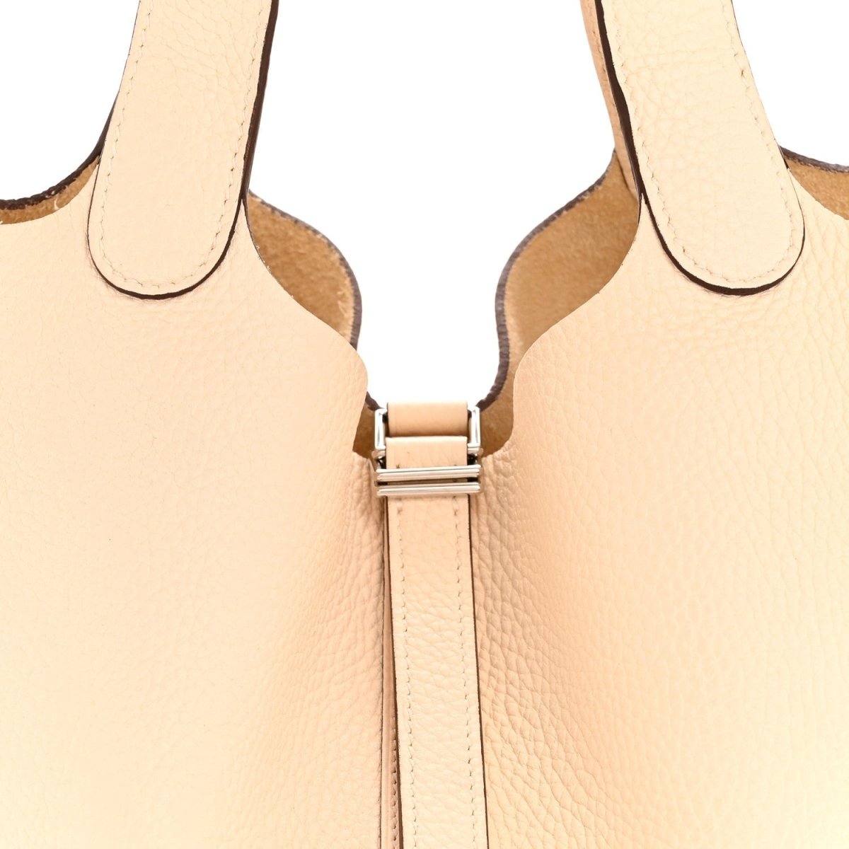 Light beige leather bucket bag front with metal lock hardware and zipper track