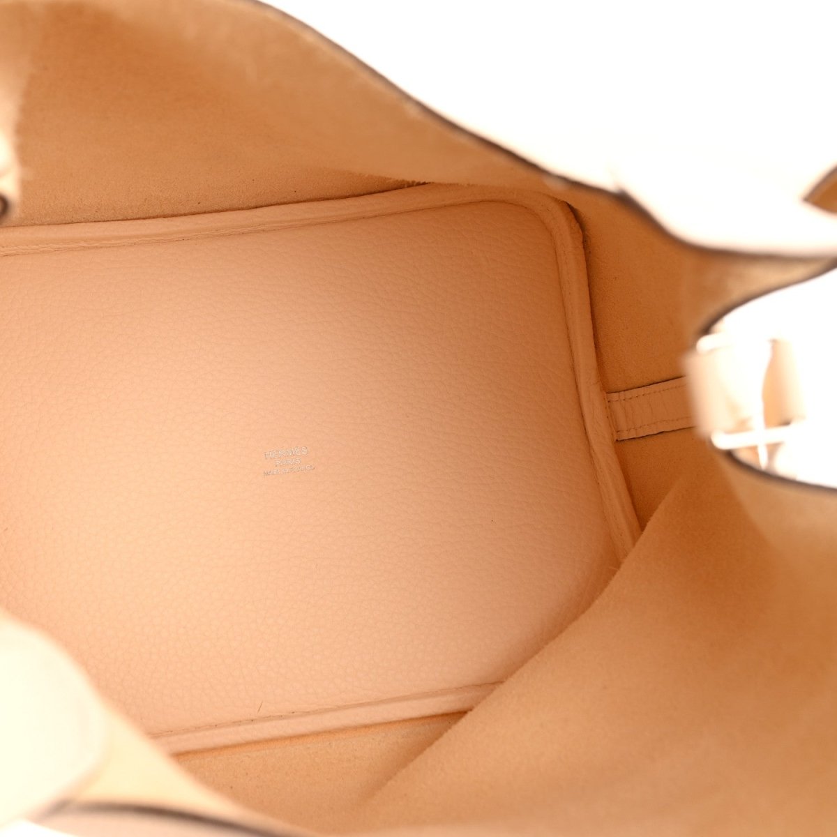 Light beige bucket bag interior with smooth tan lining and stitched edge
