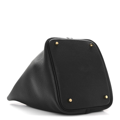 Black leather tote bag with gold-tone snap studs and angled front panel.