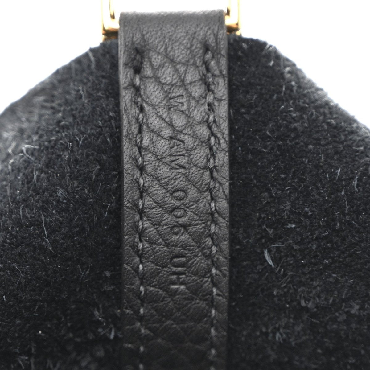 Leather handle tab with stitched edge and gold-tone top hardware loop.