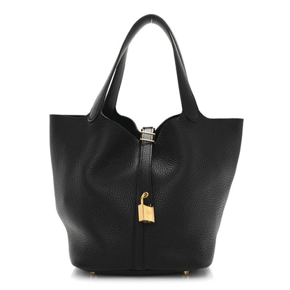 Black leather tote bag with zip lock and gold-tone hardware, structured silhouette.