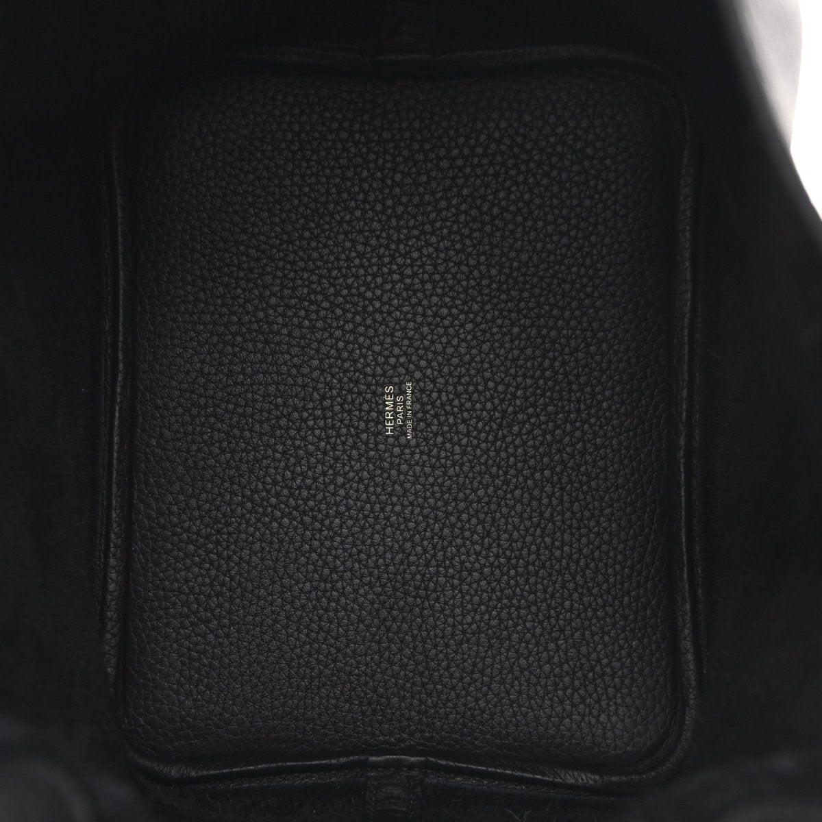 Black leather interior panel with small logo stamp and stitched side seam.