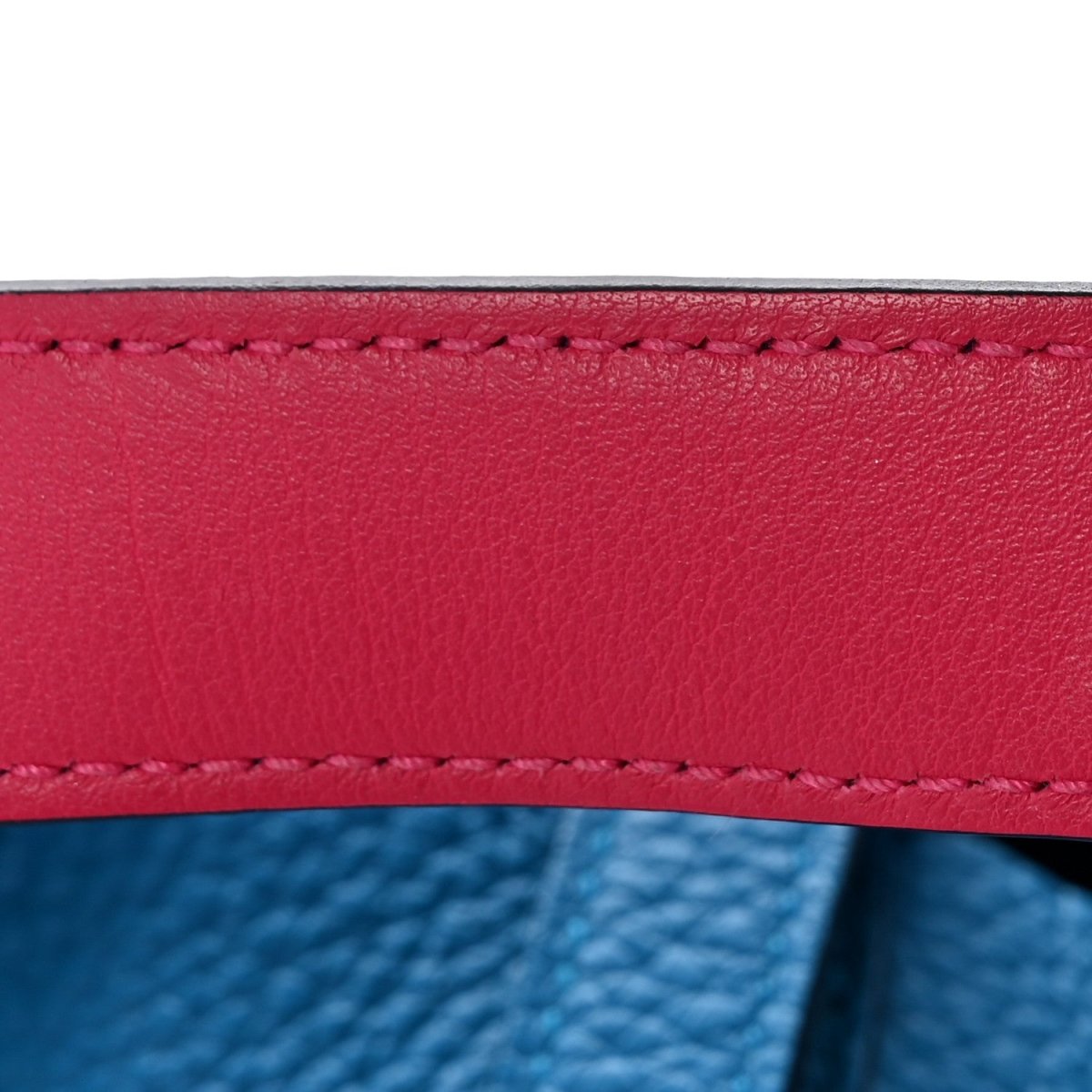 Leather bag strap with red double-row stitching, close-up