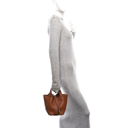 Brown leather mini tote bag on a short strap, shown from side view