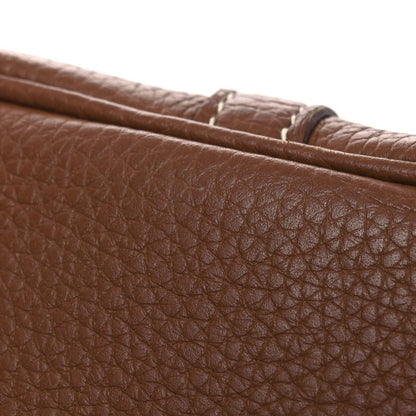 Brown leather bag with pebbled texture and stitched edge detail