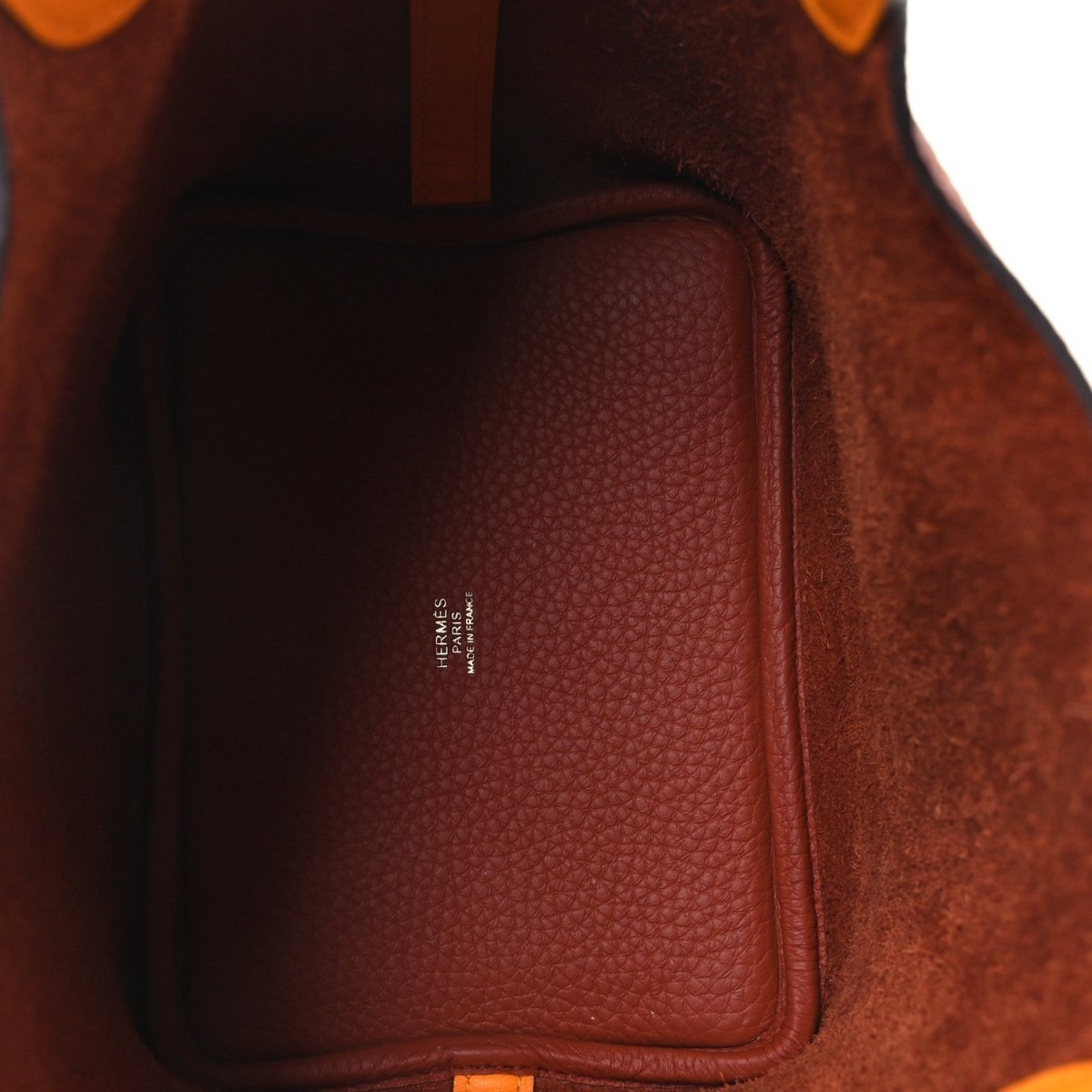 Brown leather interior panel with stitched edge and embossed brand mark
