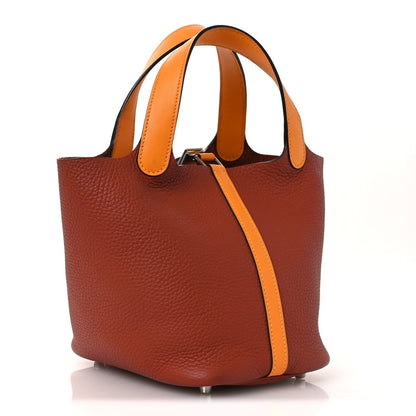 Copper-brown leather tote with tan shoulder straps and side strap closure