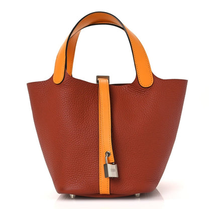 Copper-brown leather tote with tan handles and central strap closure