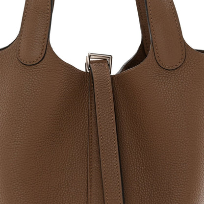 Beige leather bucket bag top view with short handles and center lock strap