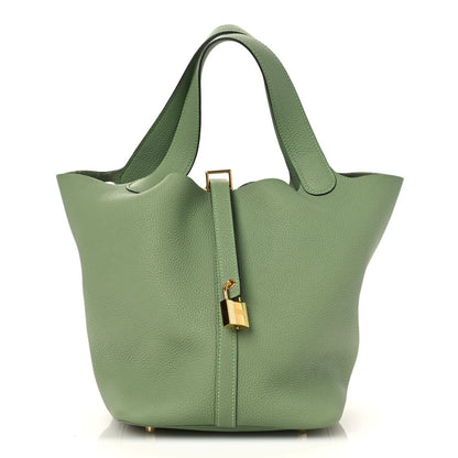 Green leather bucket bag with top handles and gold-tone lock detail on front