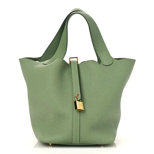 Green leather bucket bag with top handles and gold-tone lock detail on front