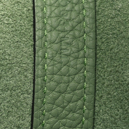 Green leather bag edge with stitched seam and textured grain