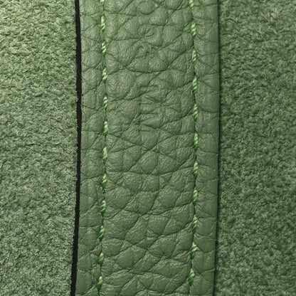 Green leather bag edge with stitched seam and textured grain