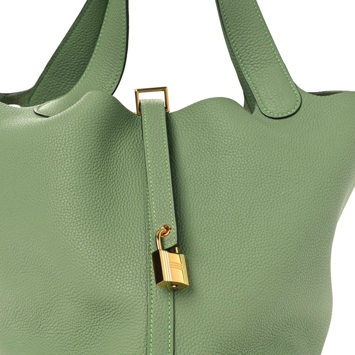 Green leather bucket bag front close-up with gold-tone lock and strap