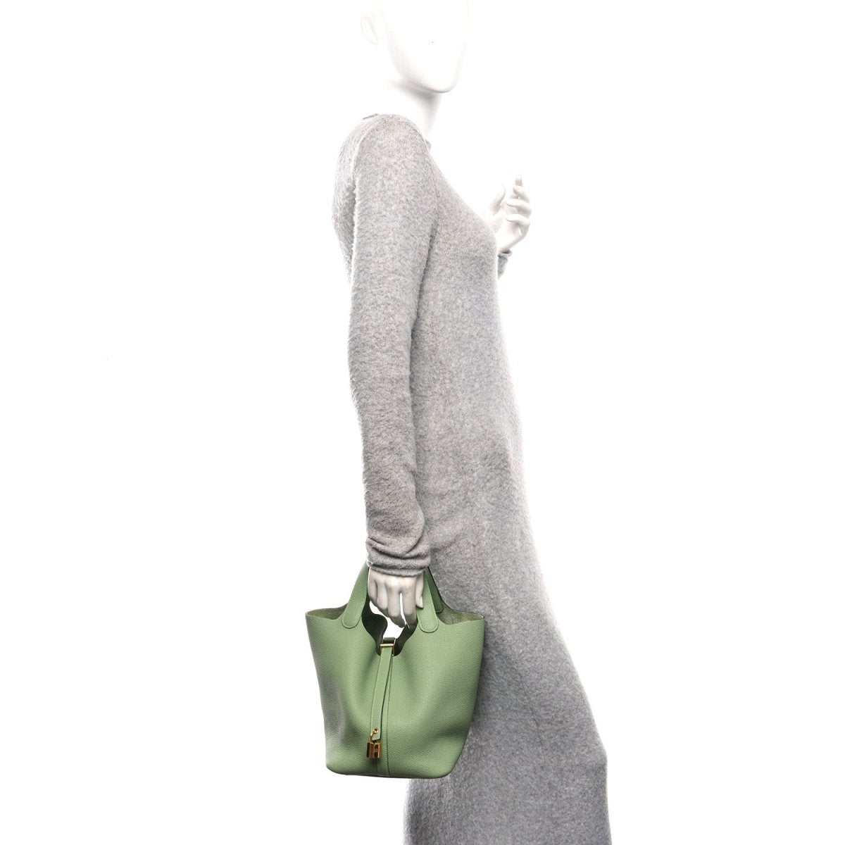 Green leather small bucket bag with top handles, held at side