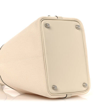 Cream canvas tote back panel with metal corner studs and curved base
