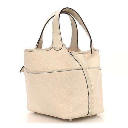 Cream canvas tote bag with top handles and front pocket with lock details
