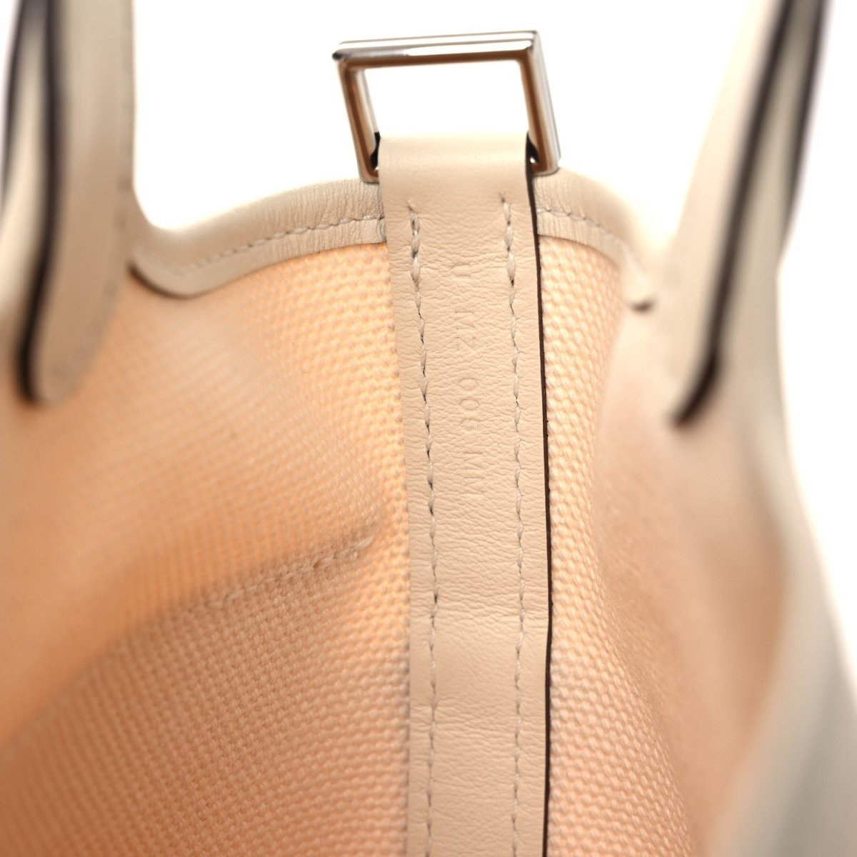 Cream canvas tote handle with metal D-ring and stitched reinforcement
