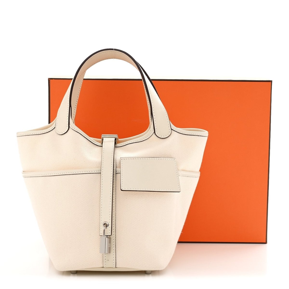 Cream canvas tote bag with top handles, front flap pocket and silver turn-lock hardware