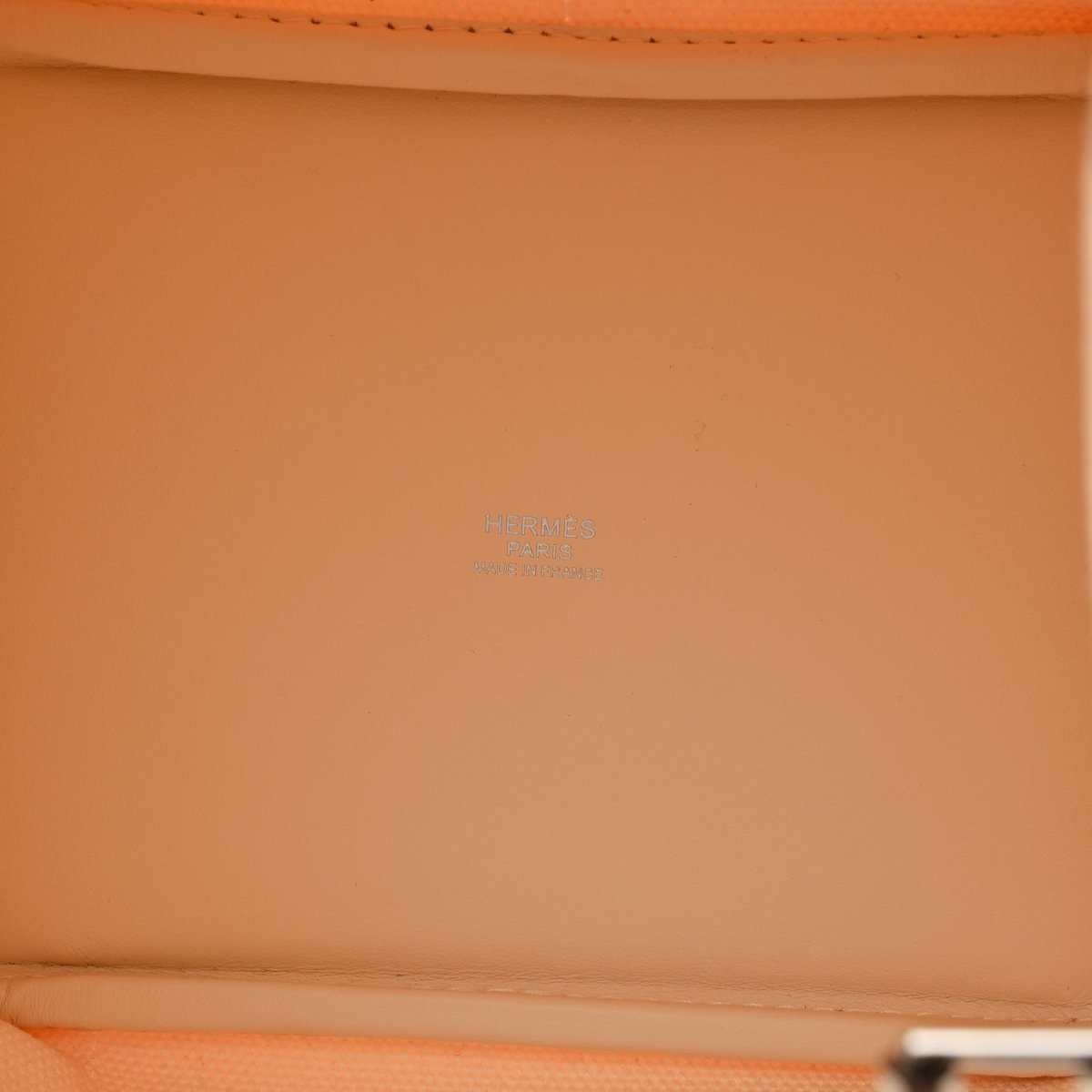 Orange leather interior panel with faint embossed logo